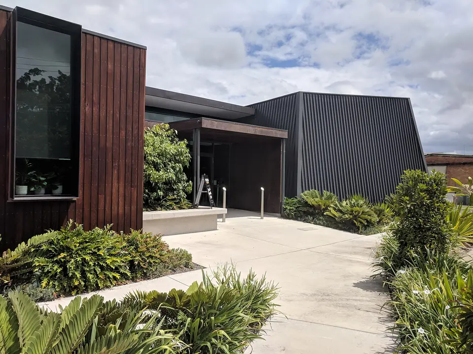 The timber-clad main entrance of the Beenleigh Rum Distillery, with native gardens.
