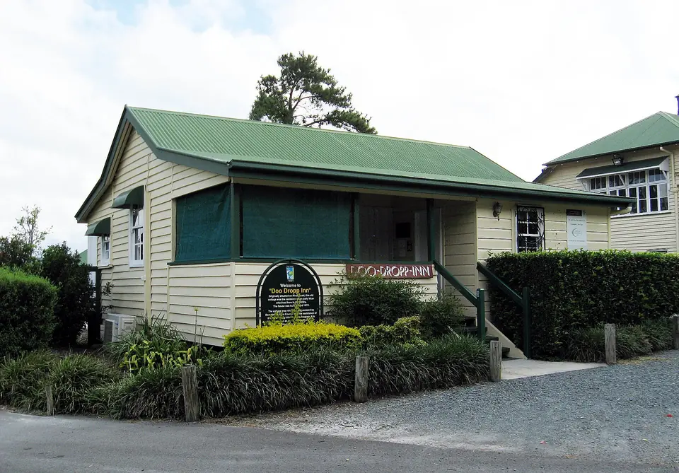 The Doo Dropp Inn, a small weatherboard building with a green roof in Logan Village.