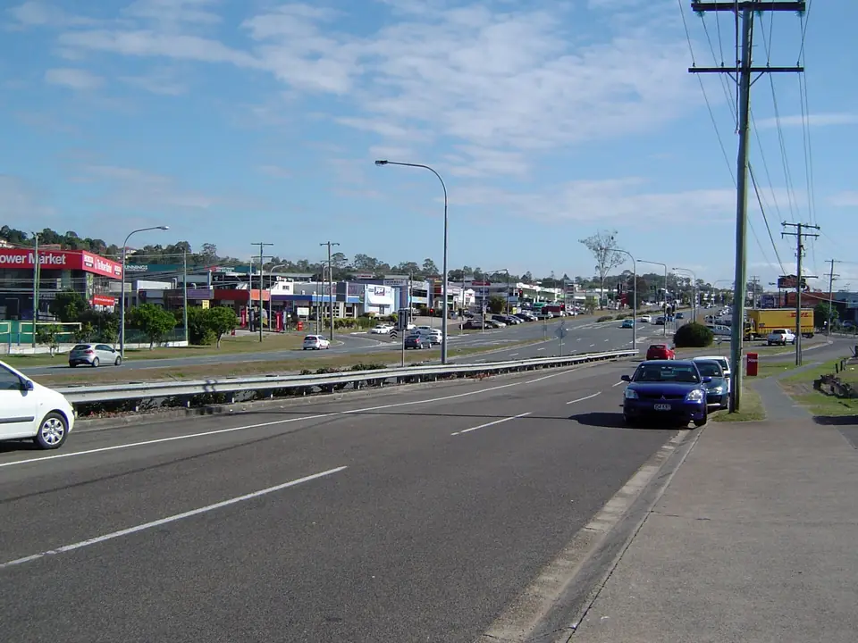 Logan Road through Underwood, lined with shops and showrooms.