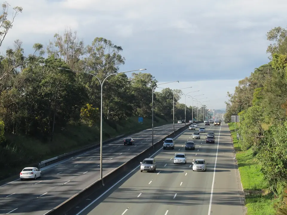Traffic on the Pacific Motorway between bushland, looking south-east from Underwood.